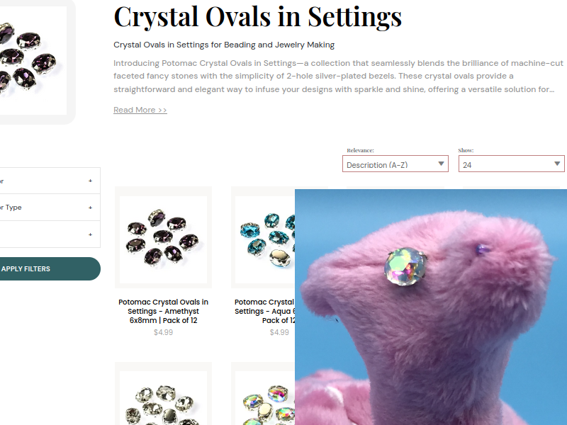 The Potomac Beads oval crystals page behind a plush dragon with them as eyes.