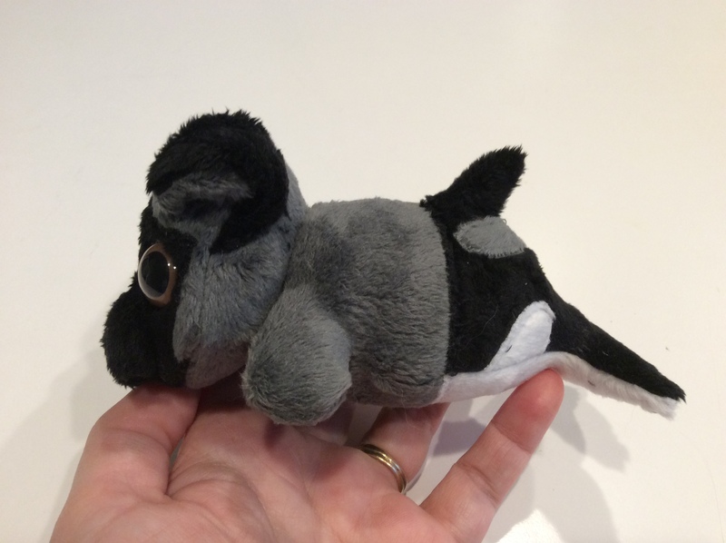 Side view of a plush pug/orca mermaid.