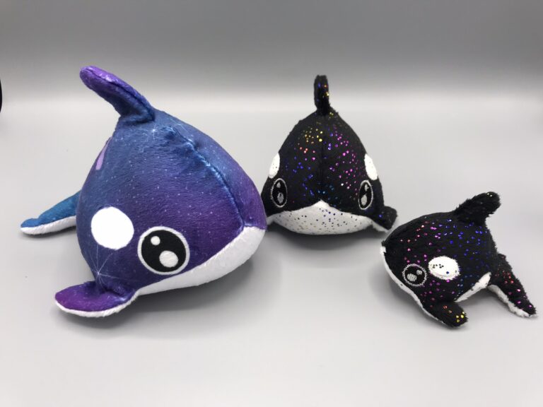 Three tiny plush orcas